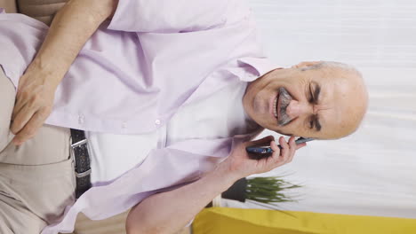 Vertical-video-of-Old-man-talking-on-the-phone-arguing.